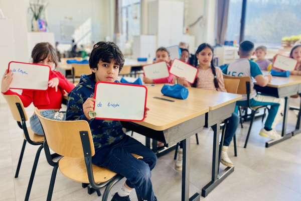 Kinderen In Klas Tonen Op Bordjes Hoe Je 'De Bussen' Schrijft Rh