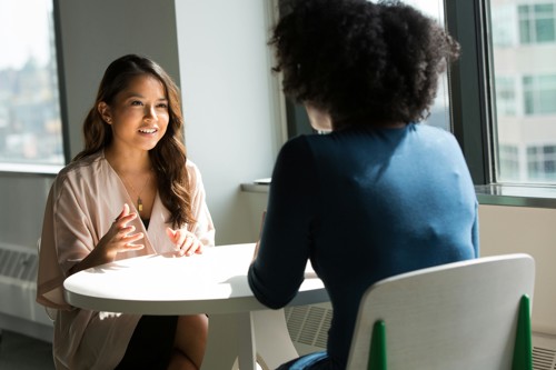 Conversatie tussen twee mensen aan een tafel